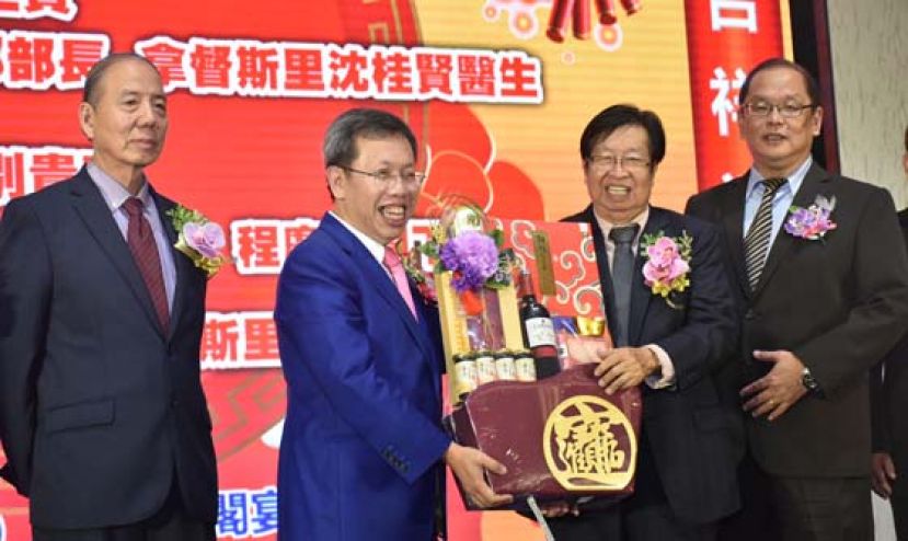 古晋榕属公会主席朱光锋（右二）赠送礼品予砂拉越地方政府与房屋部长拿督斯里沈桂贤（左二）。