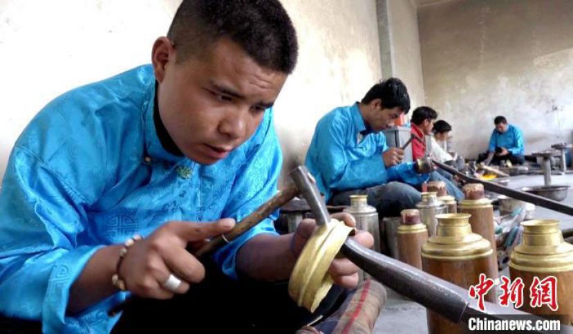 扎西吉彩匠人在打制特色暖壶。