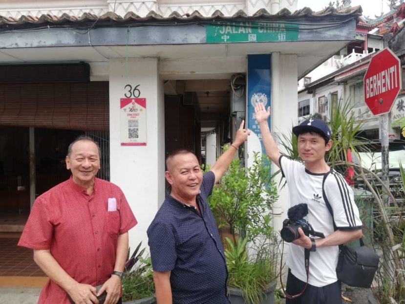 甲必丹林传政（中）向中国朝鲜族青年权威（右）介绍中国街；左是孙守生。