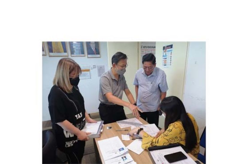 薛华东（左2）协助砂邦出生无国籍孩童办理临时证件；右2为天猛公拿督陈如飞。