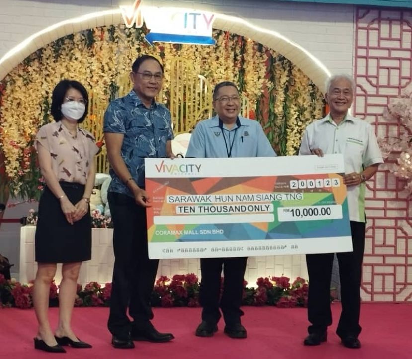 在古晋南市市长拿督黄鸿圣（右二）的见证下，Coramax有限公司董事沈耀荣（左二）移交捐款予砂拉越云南善堂正福利本固鲁田新华时摄。左1为Coramax有限公司财务总监郑堡心。