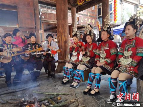 位于贵州省黎平县的肇兴侗寨，侗族姑娘和小伙在鼓楼下唱歌。