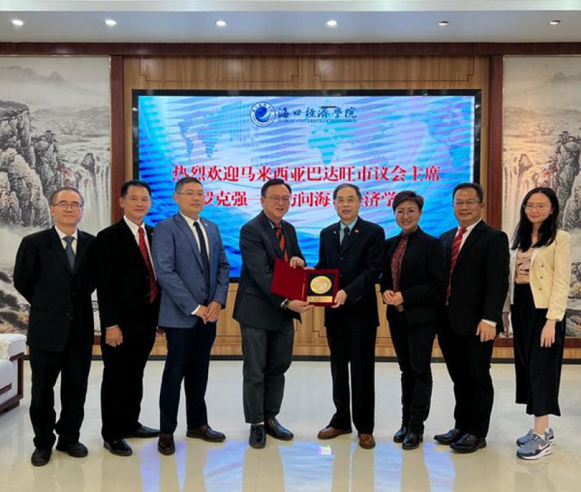 罗克强赠送纪念品给海口经院校长陈啸。