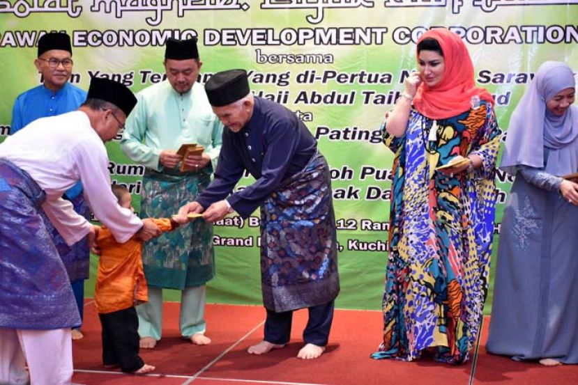 砂州元首敦泰益玛目伉俪（左三与左四）颁发礼包予斯里阿曼拿督阿志巴阿波孤儿院的孩子。