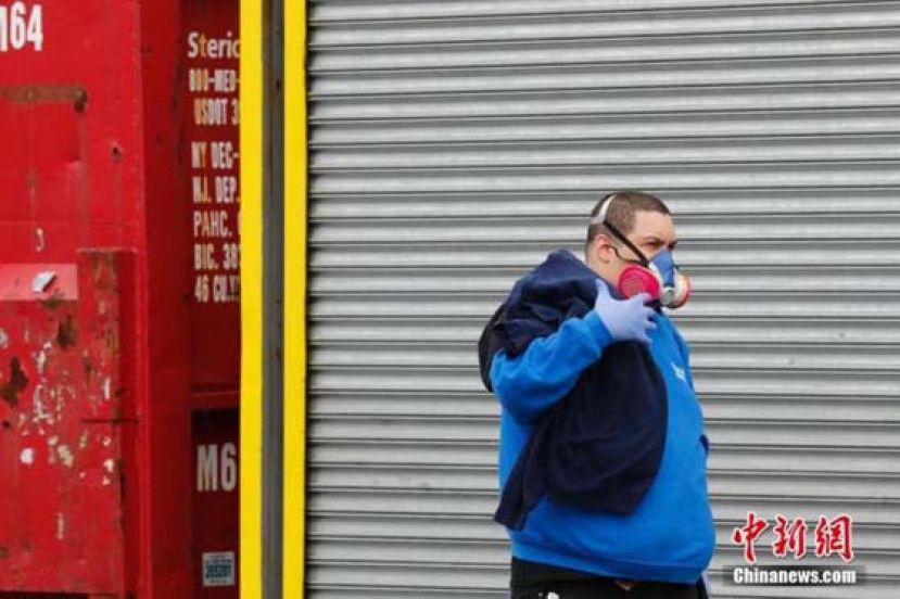 当地时间4月3日，民众佩戴呼吸面罩走过纽约布鲁克林一家医院。