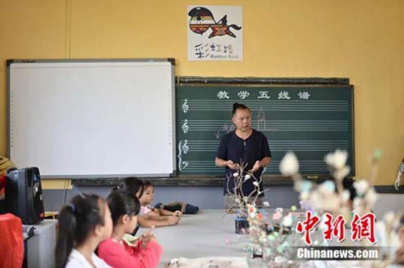 王明华在指导美术兴趣班学生。