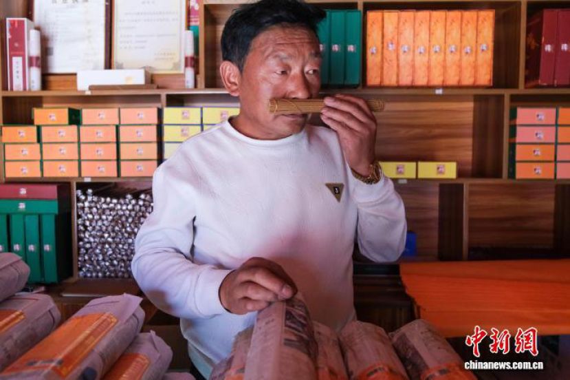 阿旺顿珠在西藏尼木县吞巴镇自家藏香店内展示手工藏香。