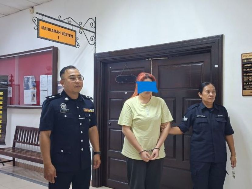 女被告被押离开法庭时影。左为查案官阿旺依斯万迪阿旺马末警长。