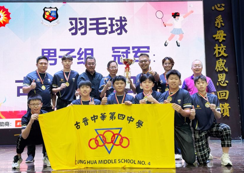 砂华文独中董联会主席天猛公拿督刘利民（后排中）移交男子组羽球冠军奖杯给四中校长官晨阳，并与全体球员合照。