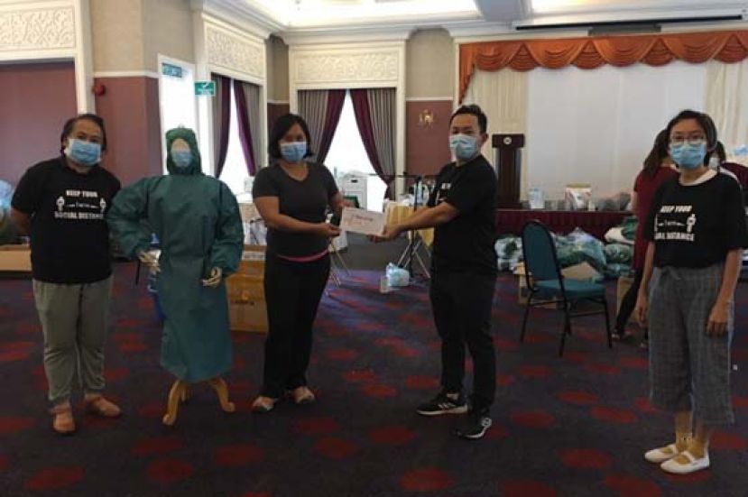 古晋省新协理事郑吕丰（右二）移交捐款给Tanoti，由该组织负责人冯应仪代收。左一为古晋新协主席贾克琳；右一为财政庄可丽。