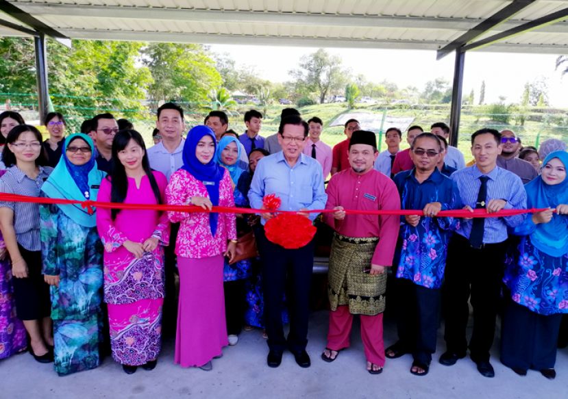 李景胜在校长、老师及家协成员见证下，为巴士候车亭启用主持剪彩。其左是校长杰莱女士。