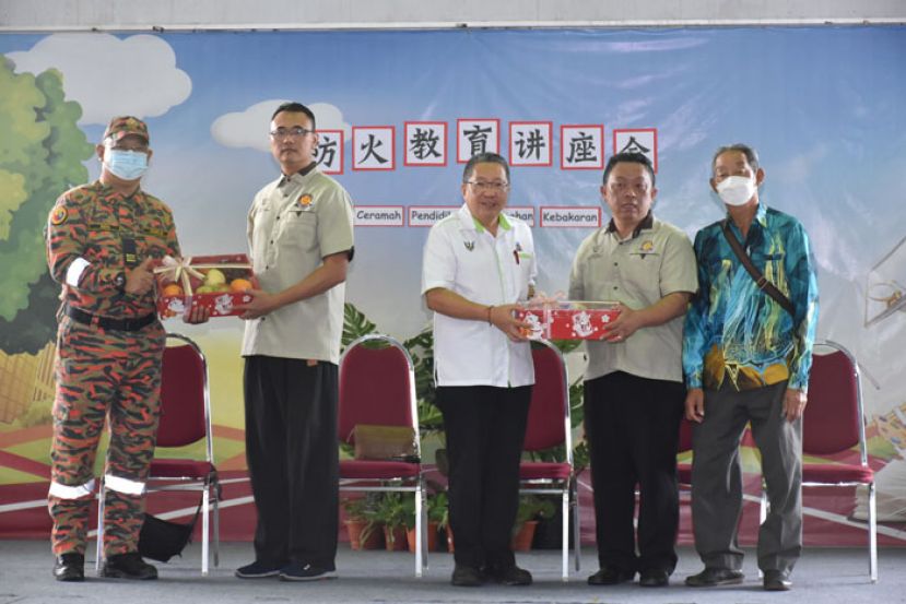 甲必丹陈德明（右二）赠送纪念品予南市市长拿督黄鸿圣（右三）、甲必丹陈俊贤（左二）赠送纪念品予消防与拯救局主讲人查布林（左一），右一为民达华国民型小学家教协会副主席郭成贵。