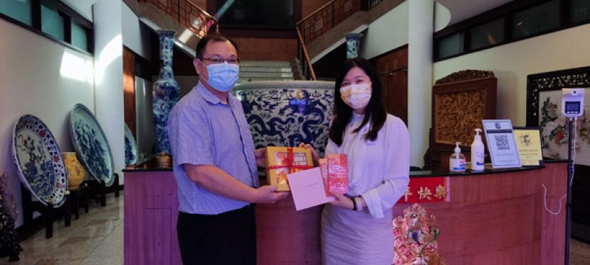 古晋河景酒店行销企划经理吴柳仪（右）移交新年蛋糕予国际时报业务发展经理陈朝忠（左）时摄。