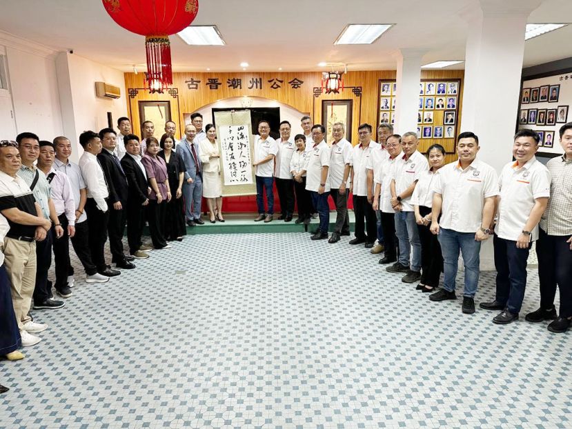 主人家古晋潮州公会会长陈家福（右十三）赠送书法墨宝予到访的广东潮人文商促进会代表团。