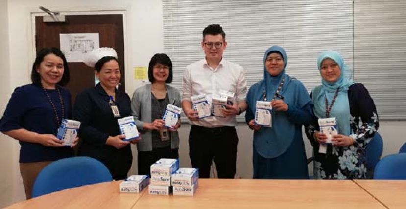 古晋市国会议员俞利文（右3）将非接触式红外体温测量计移交予砂中央医院代表后合摄。