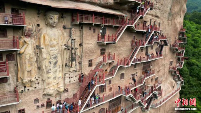 甘肃天水，游客在麦积山石窟参观。