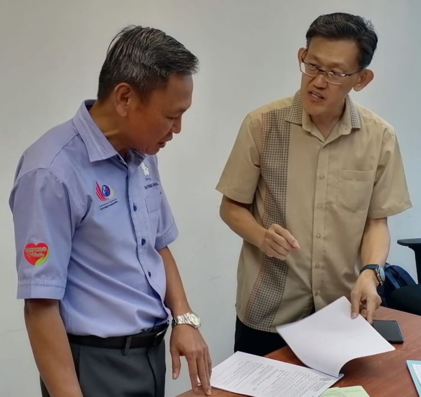 社险砂局长陈邦正（左）聆听薛华东指有善心人士资助12名单亲妈妈购社险家庭主妇计划汇报。