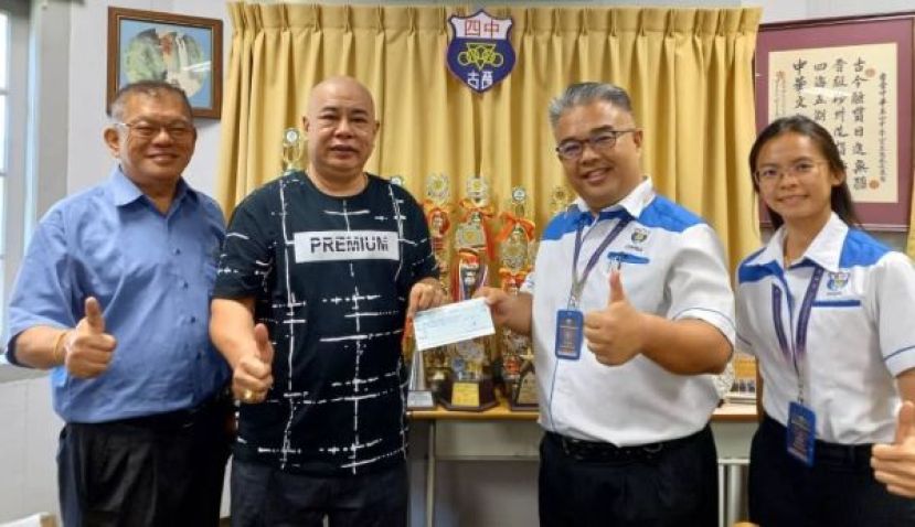 官晨阳校长（右2）从古晋宝光村俱乐部主席吴豪忠手中接过邀请四中二十四节令鼓队赞助费。左是陈中兴及右为联课主任莫静瑶。