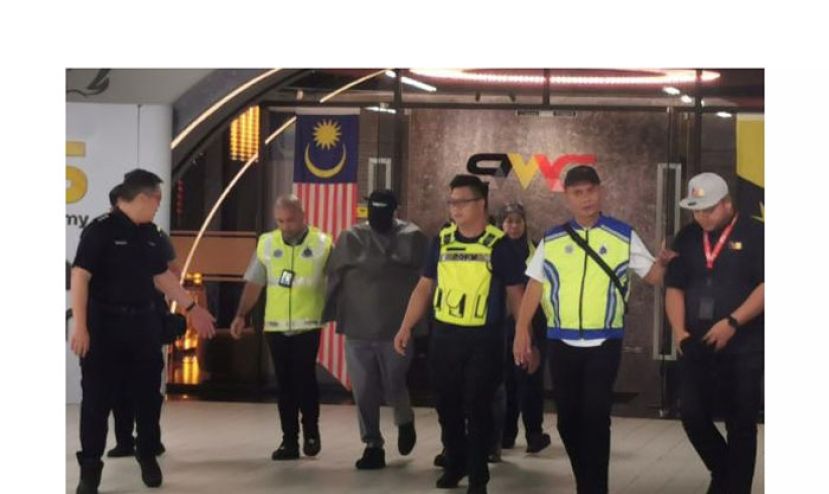 警方在砂拉越电视台总部将嫌犯押离。