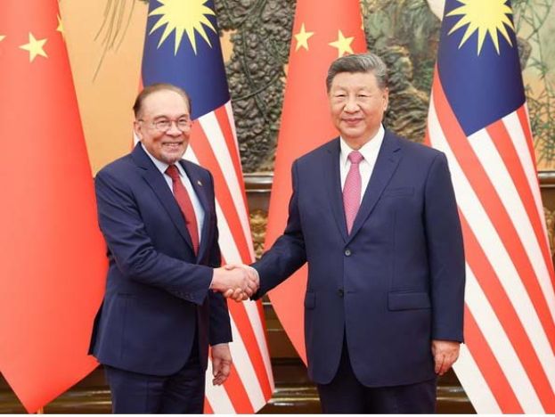 中国国家主席习近平(右)与首相安华(左)亲切握手。