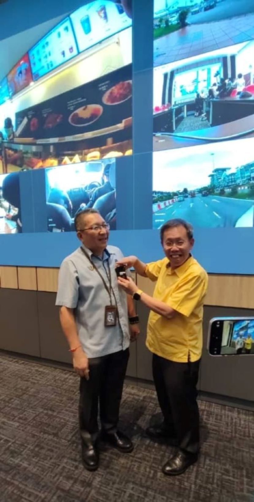 砂副总理兼房屋与地方政府部部长拿督阿玛沈桂贤（右）在进行示范南市执法人员佩戴随时摄像机时影。左为古晋南市市长拿督黄鸿圣。