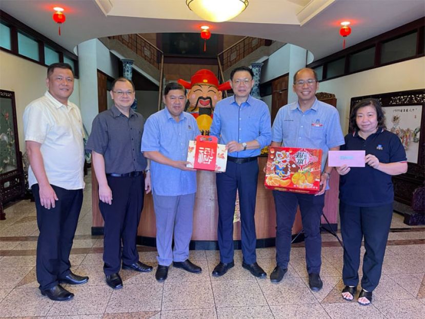 南市副市长拿督查伊迪（左三）移交新年礼品予黄文彬集团古晋经理王志强（右三），左一为蔡佑龙市议员、国际时报业务经理陈朝忠，右一为许宝玉市议员与莫壮平市议员。