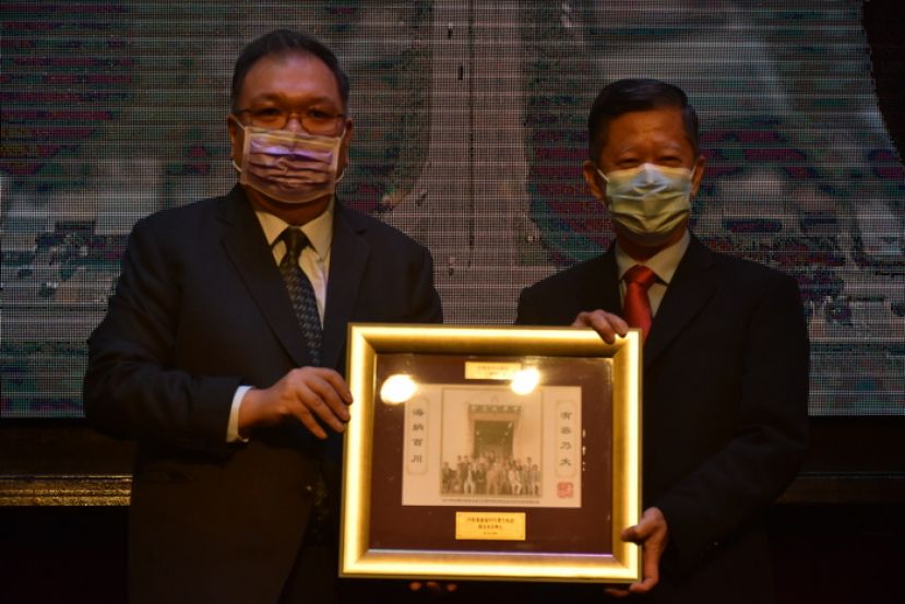 拿督黄国辉（左）把历史性的照片作为礼物赠送于古晋中华总商会会长拿督陈日枝（右）时摄。
