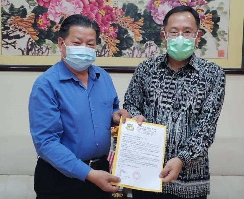  砂医总会长江宗兴（左）移交邀请担任上宾邀请函予邢伟平总领事。