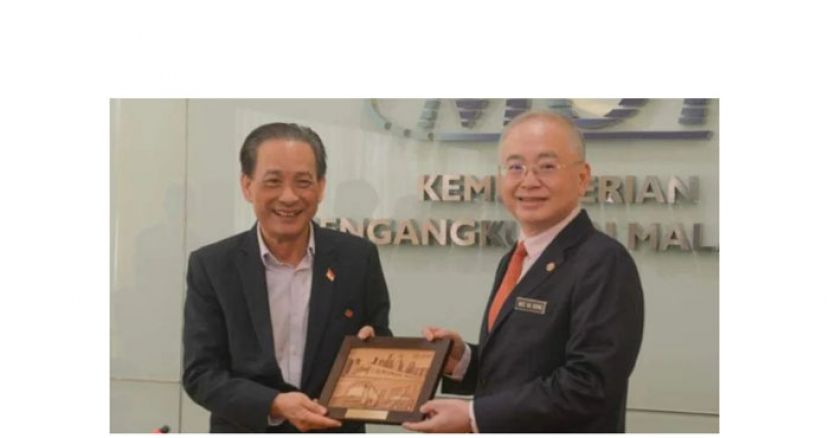 魏家祥（右）赠送纪念品予新加坡捷运公司主席佘文民（左）。