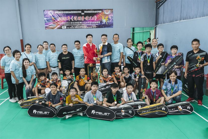 古晋中华小学第五校A代表(左七)自领取小学组团体总冠军杯时与其他优胜球员合影。左六为紫辉阁青年团团长谢嵩。右七为蔡青团长蔡春泉。