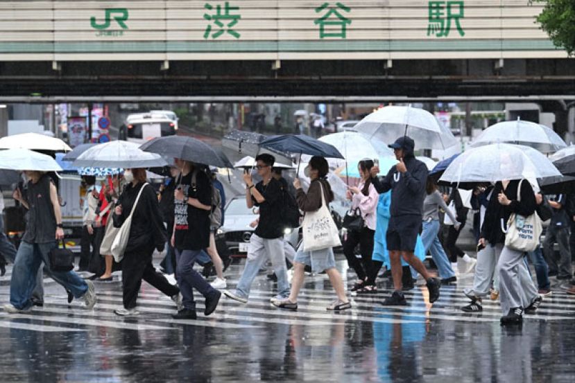 台风杜鹃逼近，日本东京已开始降雨，民众9月20日在东京涩谷区雨中撑着伞走过行人穿越道。